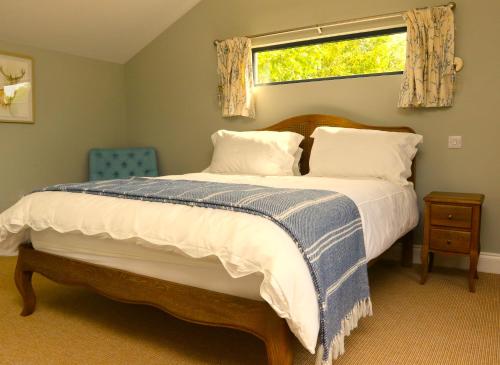 1 dormitorio con 1 cama grande y ventana en The Cabin at the Croft - Idyllic rural retreat perfect for couples and dogs en Leigh