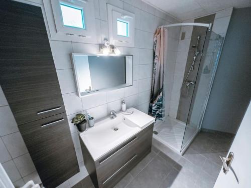 une salle de bain blanche avec un lavabo et une douche dans l'établissement Cozy 2 bedroom Artbnb Toulouse train station Garage Wi-Fi, à Toulouse