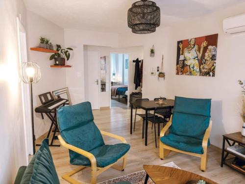 un salon avec des chaises bleues et une table dans l'établissement Cozy 2 bedroom Artbnb Toulouse train station Garage Wi-Fi, à Toulouse