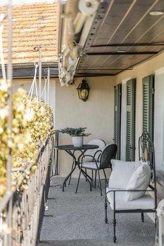 a patio with chairs and a table on a balcony at Villa Antica Colonia SPA & Wellness in Pettenasco