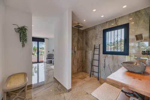 baño con lavabo, encimera y ventana en Beachside Villa in Carib Playa en Marbella