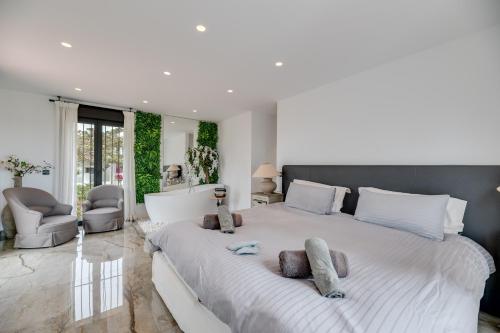 1 dormitorio con 1 cama blanca grande y 2 almohadas en Beachside Villa in Carib Playa en Marbella