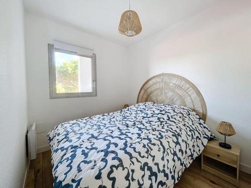 un dormitorio con una cama y una ventana en 3348 - appartement à 200m de la plage, en Le Barcarès