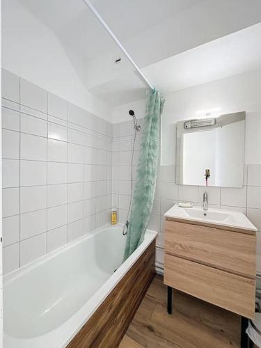 une salle de bain blanche avec une baignoire et un lavabo dans l'établissement 3348 - appartement à 200m de la plage, au Barcarès