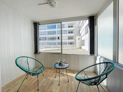 Dos sillas y una mesa en una habitación con ventana. en 3348 - appartement à 200m de la plage, en Le Barcarès