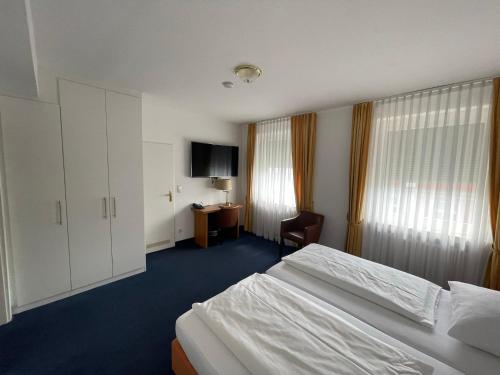 ミュンスターにあるHotel Horstmann Münsterのベッド2台とテレビが備わるホテルルームです。