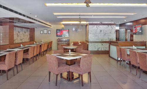 a dining room with tables and chairs in a restaurant at Hotel Cama in Chandīgarh