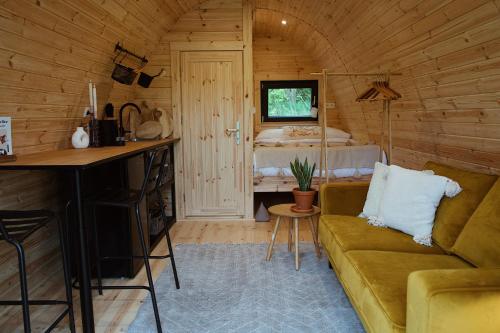 a living room with a couch and a bedroom at Knus Natuurhuisje met Hottub - Ontspannen in de natuur in Jubbega-Schurega