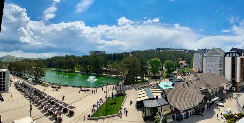 兹拉蒂博尔Apartman Daroteka的有河流和建筑物的城市景观