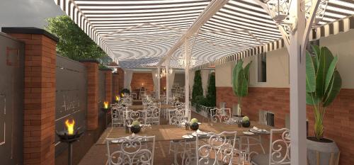 a patio with tables and chairs in a building at ALLEGRIA HOTEL Spa in Baile Unu Mai