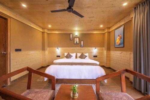 a bedroom with a bed and a ceiling fan at The Charvi Retreat Kufri Shimla by Exotic Stays I Family Accomodation I Valley & Mountain View I Kufri Shimla by Exotic Stays in Kūfrī