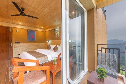 a bedroom with a bed and a table and a window at The Charvi Retreat Kufri Shimla by Exotic Stays I Family Accomodation I Valley & Mountain View I Kufri Shimla by Exotic Stays in Kūfrī