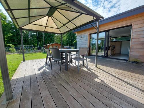 un patio con mesa y sillas en una terraza en A 200 mètres du lac d'Annecy, spacieux appartement 3 chambres avec terrasse et jardin, en Sévrier