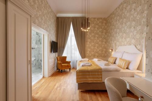 a bedroom with a bed and a desk and a chair at GOYA Vitality Hotel in Voderady