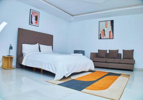 ein Schlafzimmer mit einem großen Bett und einer Couch in der Unterkunft HOTEL CONTINENTAL in Abidjan