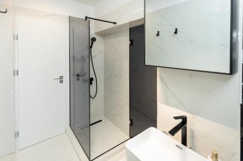 una ducha de cristal en un baño con lavabo en Fountain Bloom, en Bucarest