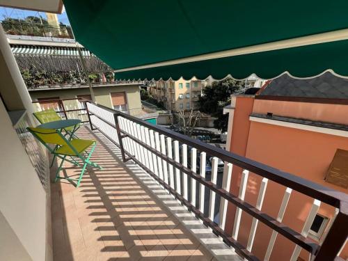 a green chair on a balcony with a green umbrella at Casa Stellina Rapallo in Rapallo