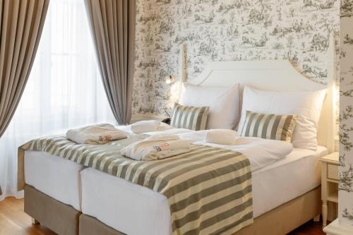 a bedroom with a large white bed in a room at GOYA Vitality Hotel in Voderady