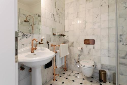 a bathroom with a sink and a toilet at GOYA Vitality Hotel in Voderady