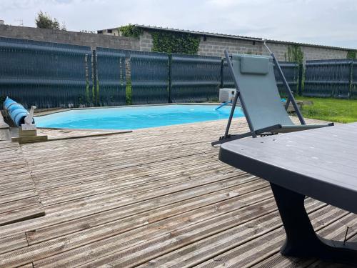 une terrasse en bois avec une table de pique-nique et une piscine dans l'établissement Maison de ville Omaha Beach, à Le Molay-Littry