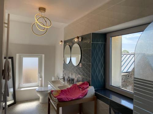 une salle de bain avec un lavabo et un miroir dans l'établissement Maison de ville Omaha Beach, à Le Molay-Littry