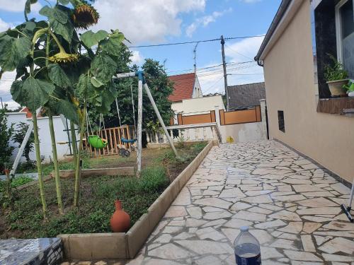 un jardin avec un arbre et une passerelle en pierre dans l'établissement BM PAVILLONS, à Goussainville