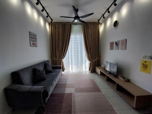 uma sala de estar com um sofá e uma ventoinha de tecto em Az Homestay @ Residensi Adelia 2 em Kajang