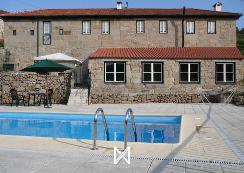 a house with a swimming pool in front of a building at MyStay - Casa da Portaria in Tarouca