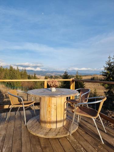 a wooden table and chairs on a wooden deck at Glamping 4 us in Topliţa