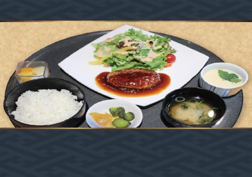a plate of food with rice and vegetables on a table at Route Inn Grantia Tokai Spa&Relaxation in Tokai