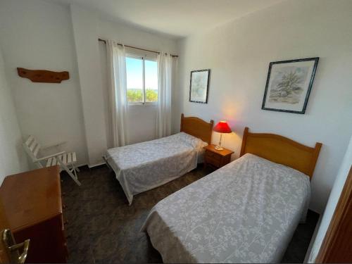 ein Hotelzimmer mit 2 Betten und einem Fenster in der Unterkunft Apartamentos Cap y Corp in Alcossebre