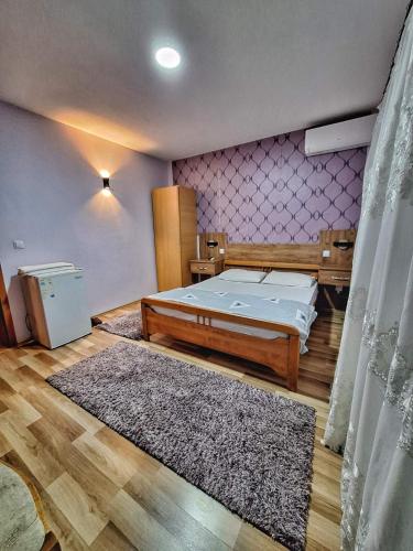 a bedroom with a bed and a rug at Evropa in Gračanica