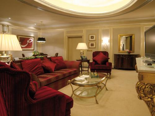 a living room with a red couch and a table at Mövenpick Hotel Al Khobar in Al Khobar