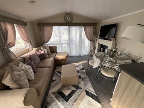 a living room with a couch and a table at Seaview Caravan 2 Bedroom Sleeps 6 -WiFi -Smart Tv in Colchester