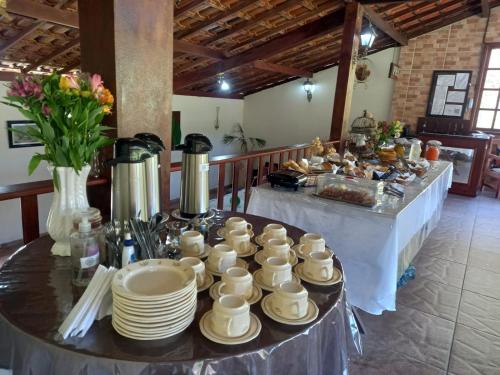 a table with white cups and plates on it at Hortênsias da Serra Pousada in Nova Friburgo