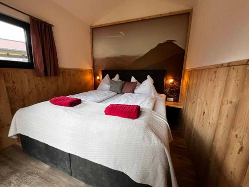a bedroom with a large bed with red pillows on it at Meine kleine Auszeit - Die Schlafhütten in Sankt Georgen am Reith