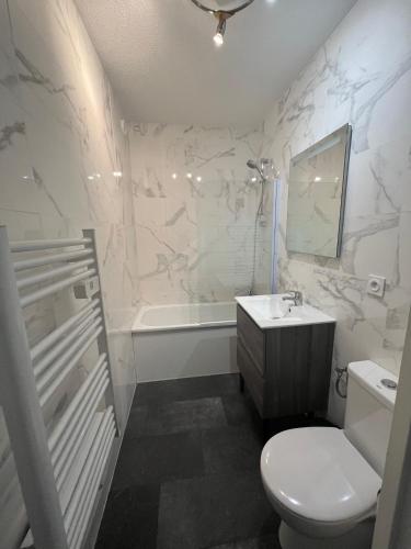 une salle de bain avec toilettes, baignoire et lavabo dans l'établissement Guéthary Kurlinka - appartement avec balcon - place de stationnement privée, à Guéthary