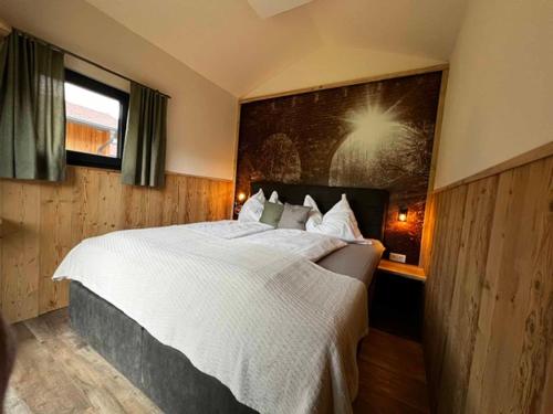 a bedroom with a large bed and a painting on the wall at Meine kleine Auszeit - Die Schlafhütten in Sankt Georgen am Reith