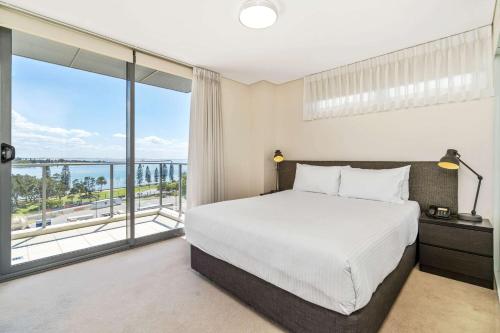 a bedroom with a bed and a large window at Terminus Apartment Hotel, Ascend Hotel Collection in Newcastle