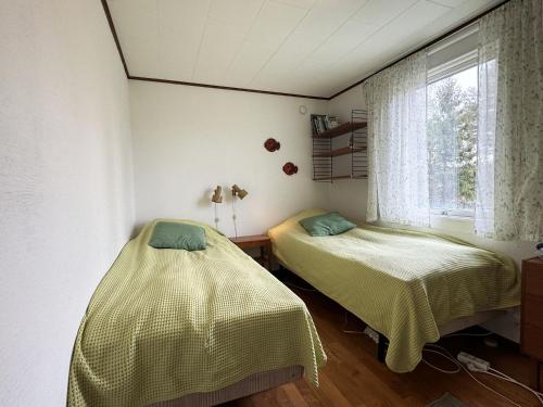Duas camas num quarto com uma janela em Cozy cottage in a beautiful setting by the Abyfjorden-Brastad em Brastad