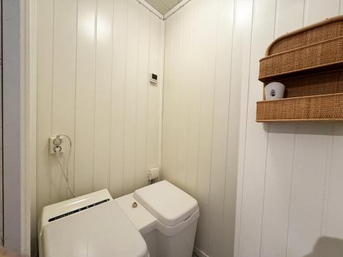 uma pequena casa de banho com um WC branco e uma prateleira em Cozy cottage in a beautiful setting by the Abyfjorden-Brastad em Brastad