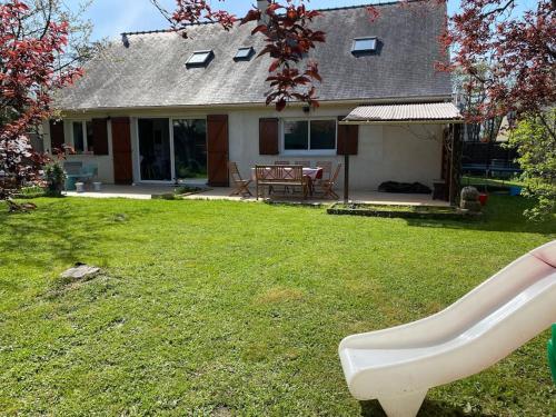 une maison avec un banc blanc dans la cour dans l'établissement Grande maison familiale au calme, à Bouchemaine