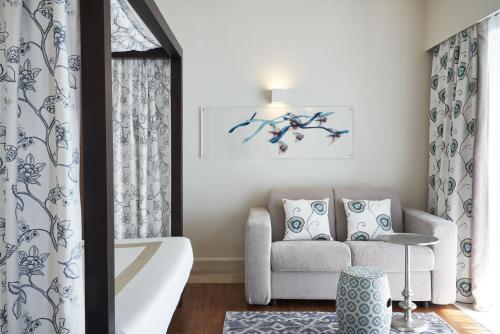 a living room with a couch and a chair at Aquagrand Artistic Luxury Beach Resort - Adults Only in Líndos