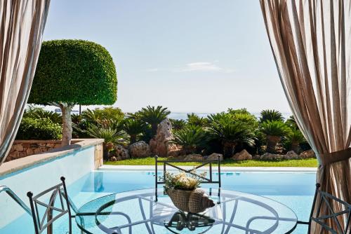 a view of a swimming pool through a window at Aquagrand Artistic Luxury Beach Resort - Adults Only in Líndos