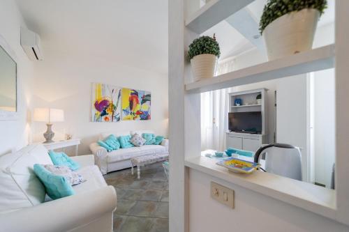 ein Wohnzimmer mit einer weißen Couch und einem Tisch in der Unterkunft EasyTopStay - Porto Ercole Cosy Flat in Porto Ercole