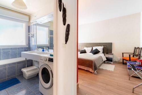 une chambre avec un lit et une salle de bains avec un lave-linge dans l'établissement Bel appartement avec terrasse et parking gratuit, à Massy