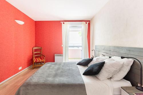 une chambre avec un grand lit aux murs rouges dans l'établissement Bel appartement avec terrasse et parking gratuit, à Massy