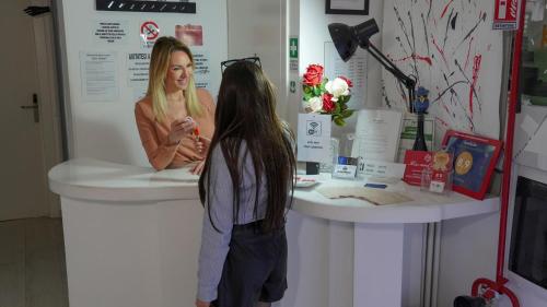 a woman talking to a girl in a hair salon at Caos Calmo in Rome