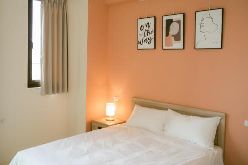 a bedroom with a bed and three pictures on the wall at 三三旅宿33 Bed & Breakfast in Lugang