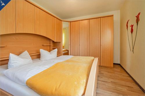 a bedroom with a large bed and wooden cabinets at Am Schulberg Ferienhaus Albatros in Heringsdorf